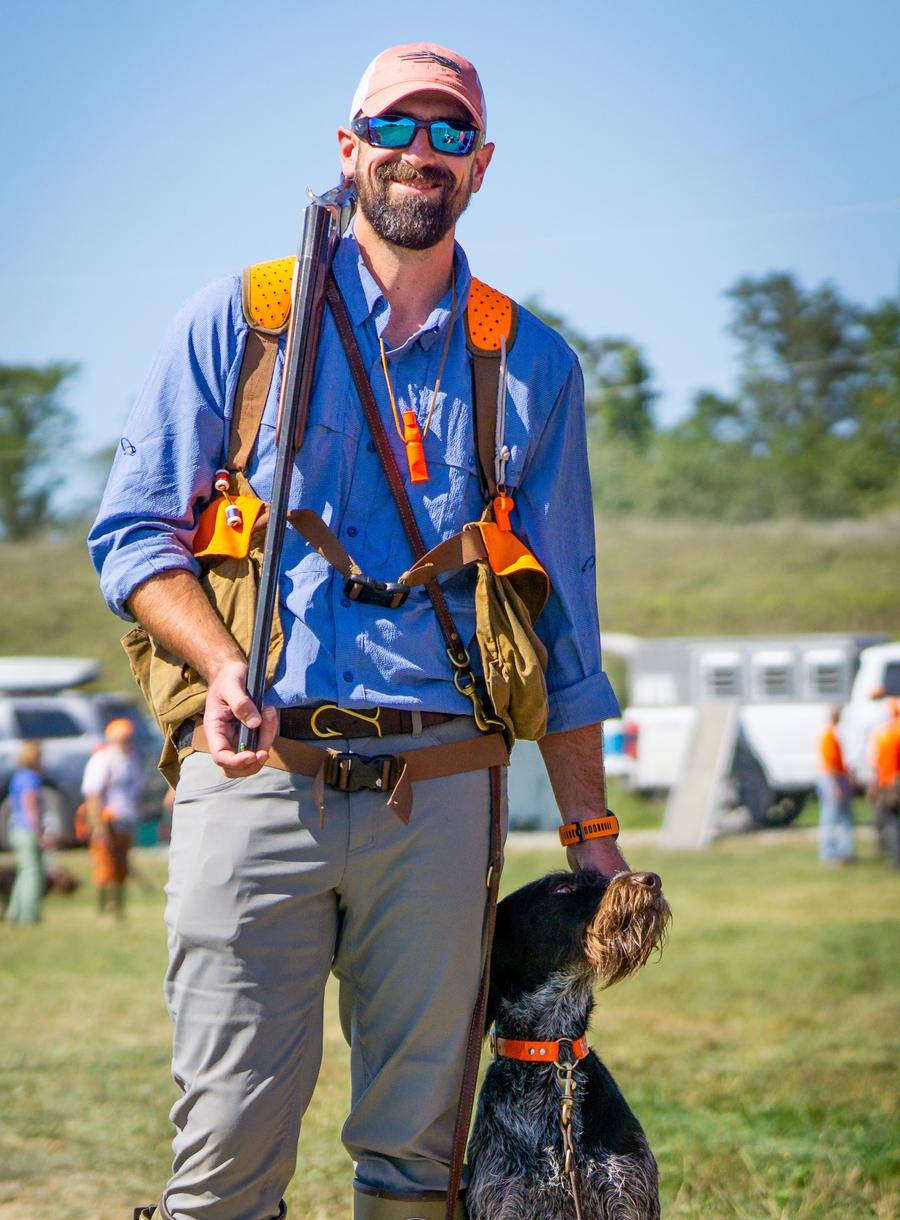 PJ standing with his wirehaired pointing dog at a test day